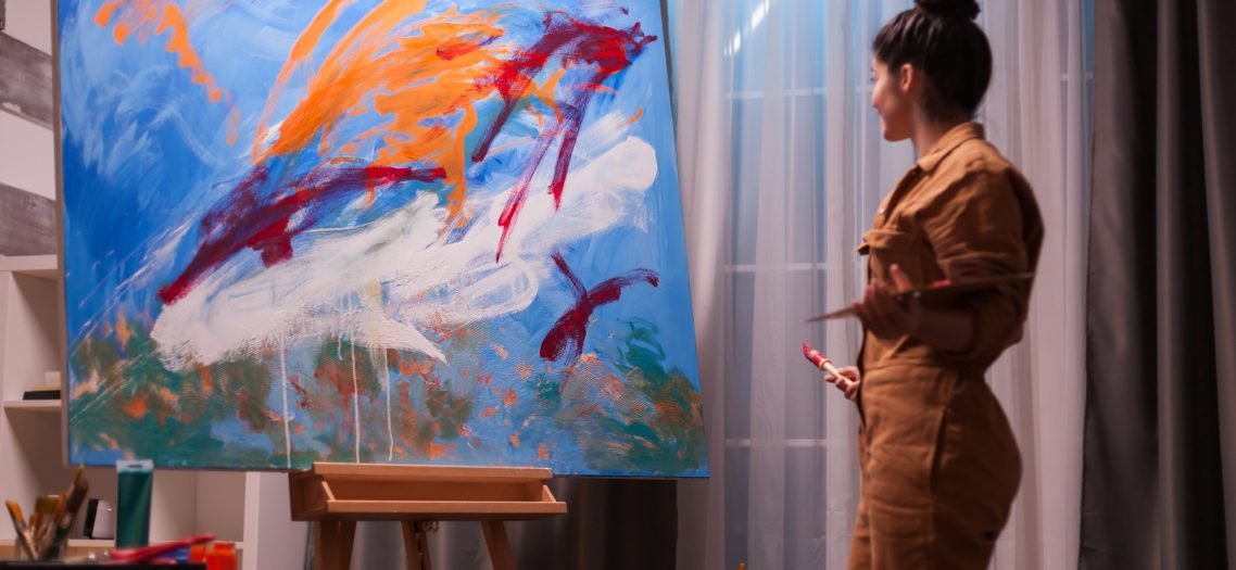 Happy artist in art studio Happy artist in art studio after creating a masterpiece on large canvas. Modern artwork paint on canvas, creative, contemporary and successful fine art artist drawing masterpiece