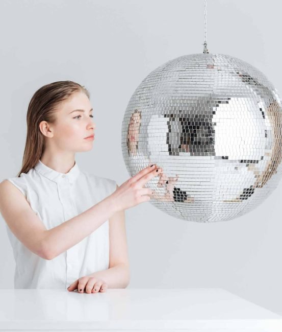 woman-sitting-at-the-table-with-mirror-ball-PBU8DV4-scaled.jpg